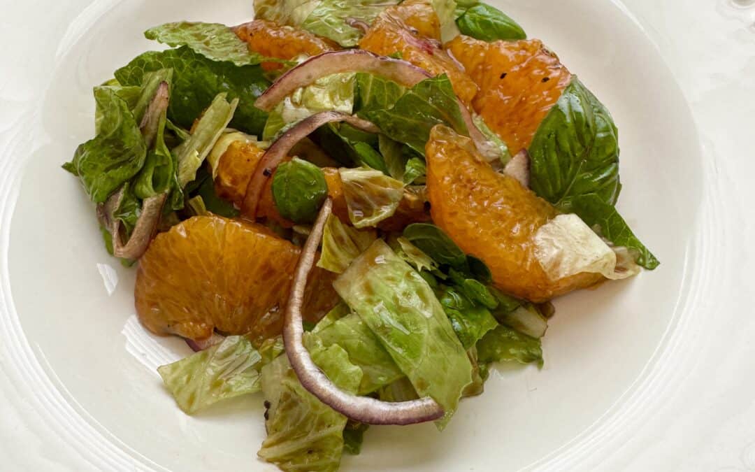 Fresh orange basil salad with romaine, red onion, and orange segments, drizzled with orange balsamic vinaigrette